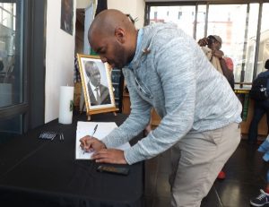 Un homme laisse un message, hier, sur le registre de condoléances à l’embarcadère pour Robben Island, l’ancienne île prison au large du Cap