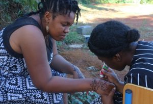 Fatima se fait mettre du henné par Samna pour peaufiner son personnage