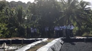 Les élus et les cadres du SIEAM écoutent le maire de Koungou devant les bassins de la mini STEP